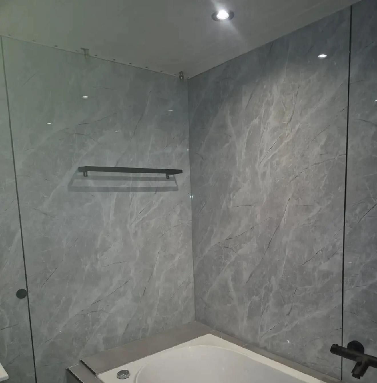 Whirlpoolbad voor een wand van grijze tegels in marmerlook