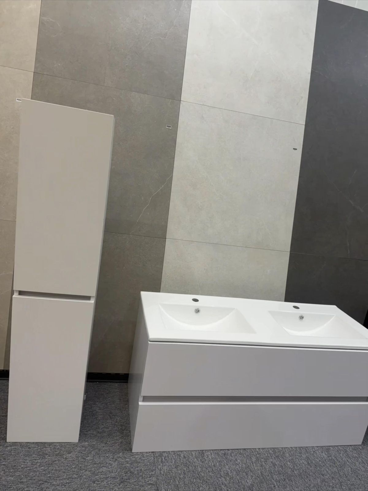 Witte wastafelmeubels met dubbele wastafel en een hoge kast in de showroom